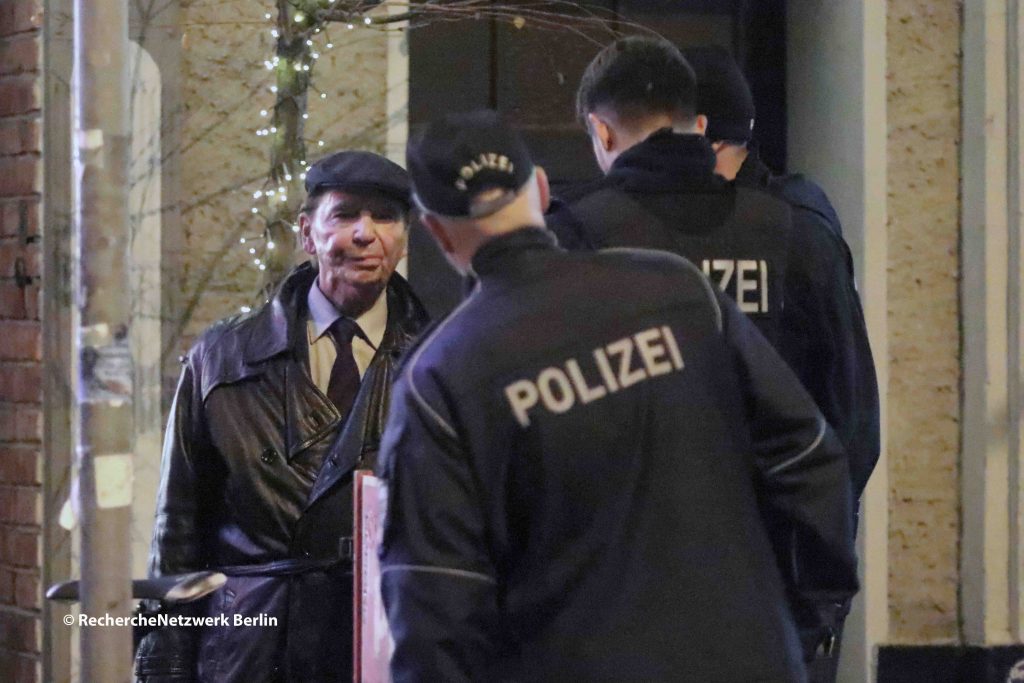 Hans-Ulrich Pieper verhandelt mit der Polizei wie die Versammlung die Räume des Cafe Breslau zu verlassen hat. Die TeilnehmerInnen wollten möglichst unerkannt bleiben.  @ RechercheNetzwerk_Berlin